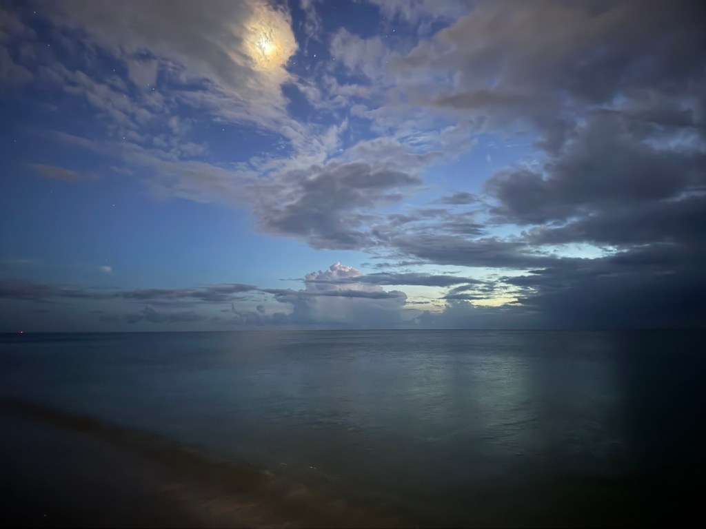 ocean view at dusk  in Naples. Blue sky, grey clouds that melt ito the bluish grey water